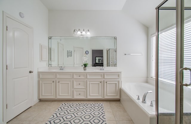 bathroom featuring tile patterned flooring, vanity, independent shower and bath, and vaulted ceiling