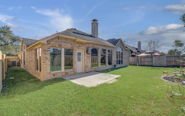 back of property featuring a lawn, cooling unit, and a patio area