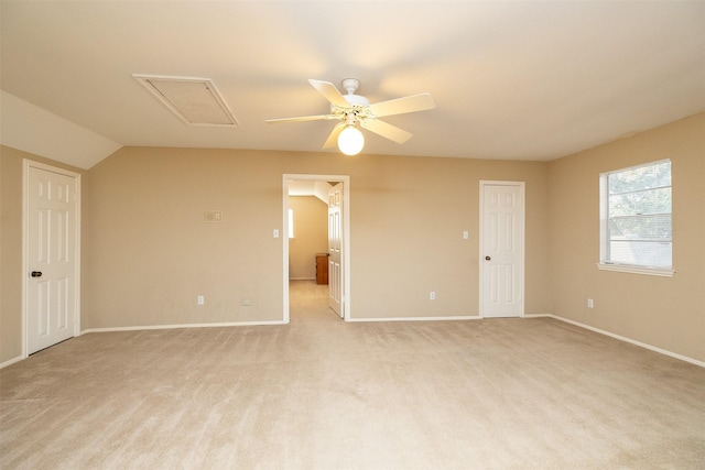 empty room featuring ceiling fan, light colored carpet, and vaulted ceiling