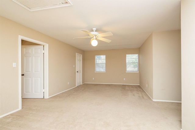 spare room with ceiling fan and light colored carpet