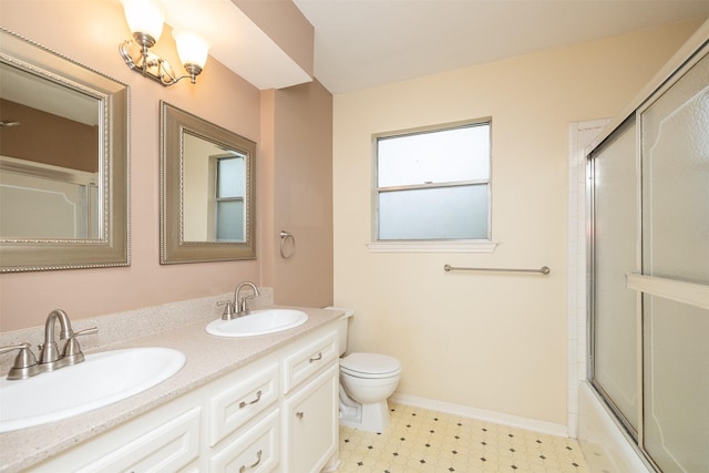 full bathroom featuring vanity, toilet, and bath / shower combo with glass door