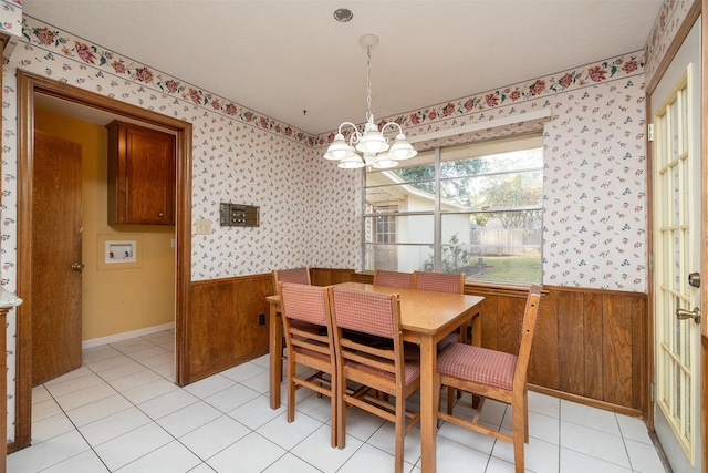 tiled dining room with a notable chandelier and wood walls