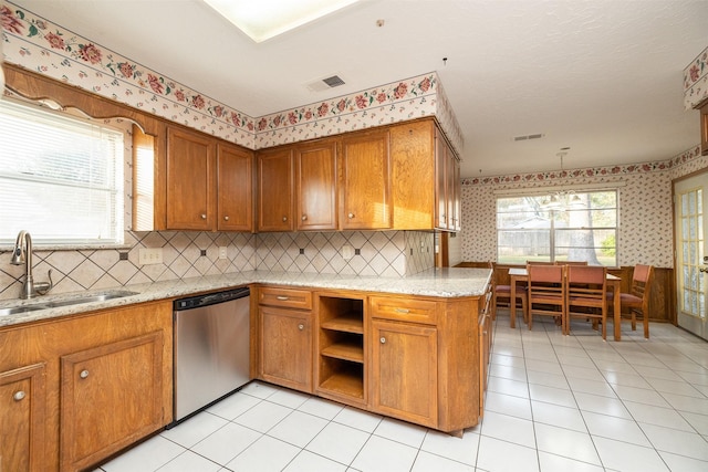 kitchen featuring light stone countertops, tasteful backsplash, stainless steel dishwasher, sink, and light tile patterned flooring