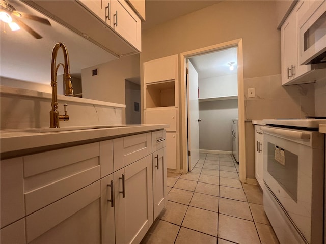 kitchen with white cabinets, ceiling fan, white appliances, and light tile patterned floors