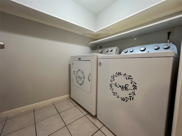 washroom featuring washing machine and dryer and light tile patterned flooring