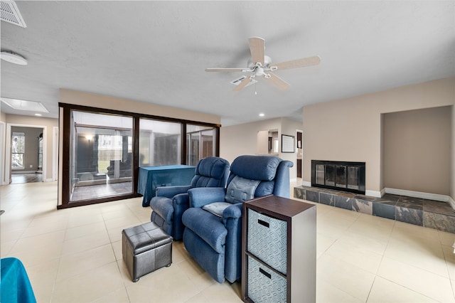 living room featuring ceiling fan and a fireplace