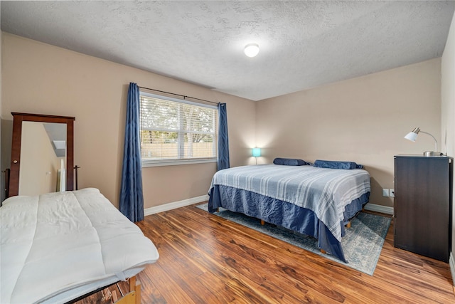 bedroom featuring a textured ceiling and hardwood / wood-style flooring