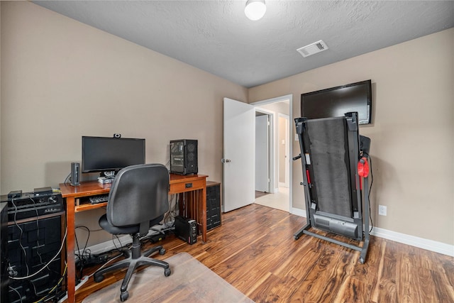 home office featuring hardwood / wood-style floors and a textured ceiling