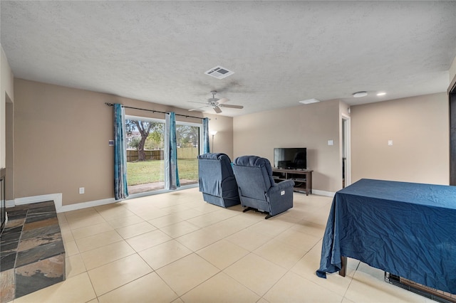 bedroom with ceiling fan, light tile patterned flooring, and a textured ceiling