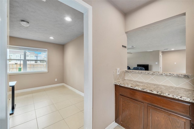 bathroom with tasteful backsplash, vanity, and a textured ceiling