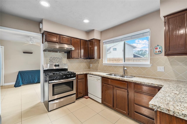 kitchen featuring tasteful backsplash, white dishwasher, ceiling fan, sink, and stainless steel range with gas cooktop