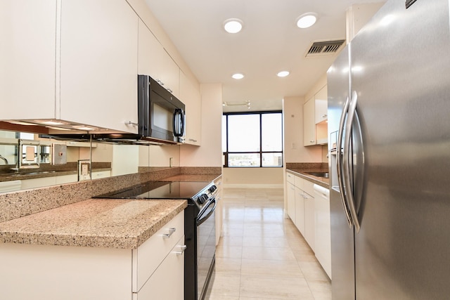 kitchen featuring light stone counters, white cabinets, and stainless steel appliances