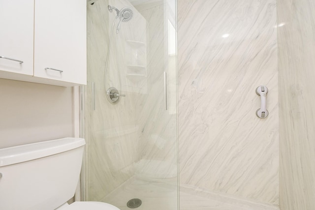 bathroom featuring tiled shower and toilet