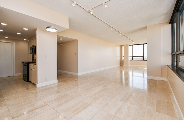 spare room with a textured ceiling and rail lighting