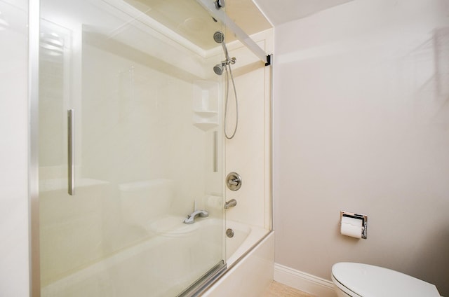 bathroom featuring combined bath / shower with glass door and toilet