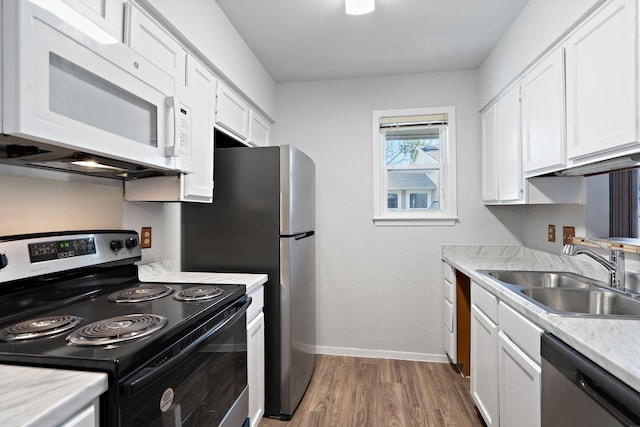 kitchen featuring light wood-type flooring, white cabinetry, sink, and appliances with stainless steel finishes