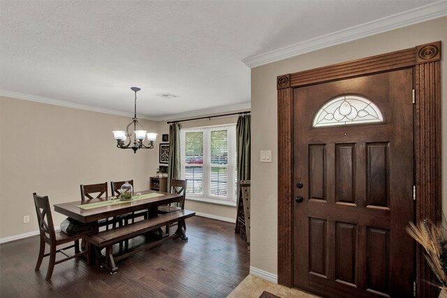 entryway featuring dark hardwood / wood-style floors, ornamental molding, and a chandelier