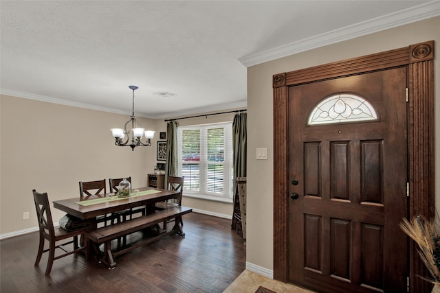 foyer featuring crown molding, dark hardwood / wood-style floors, and a chandelier