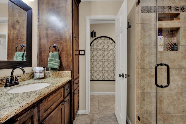 bathroom featuring a shower with door, vanity, and tile patterned flooring