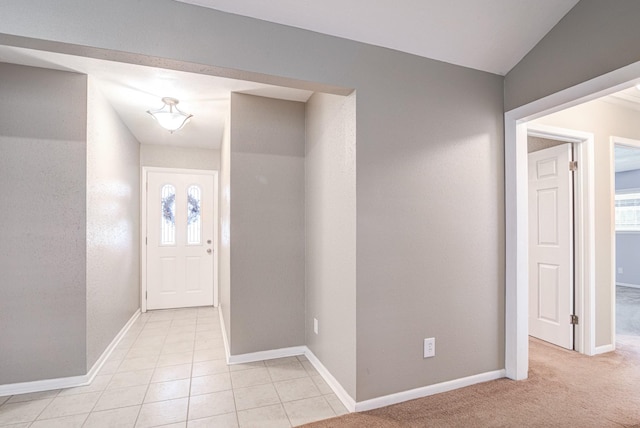 carpeted foyer with a healthy amount of sunlight and vaulted ceiling