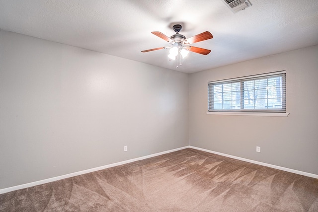 carpeted spare room featuring ceiling fan and a textured ceiling