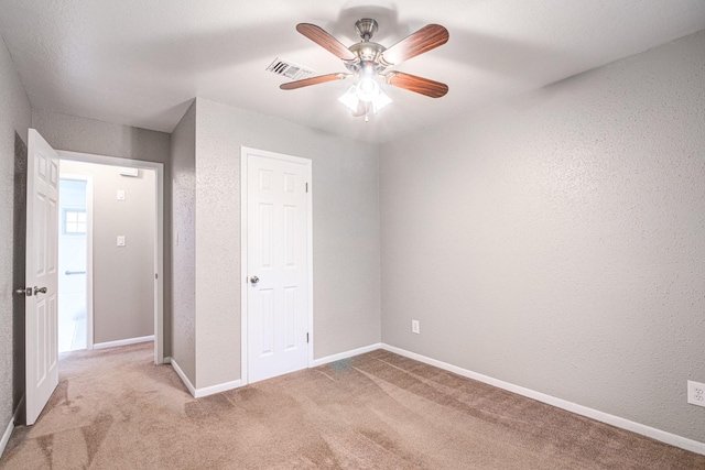 unfurnished bedroom with ceiling fan and light colored carpet