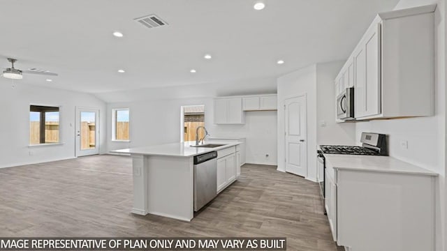 kitchen with light wood-type flooring, sink, stainless steel appliances, and an island with sink