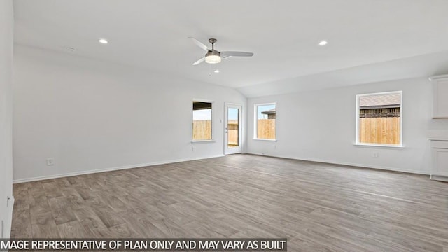 empty room featuring ceiling fan, a healthy amount of sunlight, light hardwood / wood-style floors, and vaulted ceiling