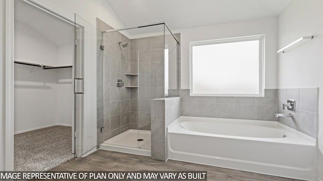 bathroom with wood-type flooring, vaulted ceiling, and independent shower and bath