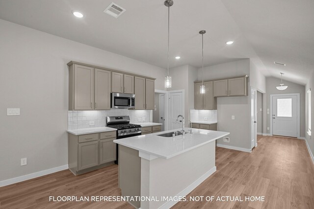 kitchen with sink, hanging light fixtures, vaulted ceiling, light hardwood / wood-style floors, and stainless steel appliances