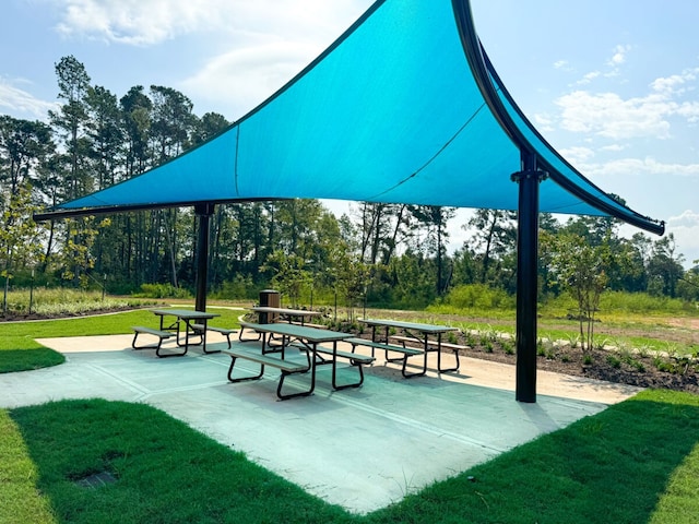 view of community with a patio and a lawn