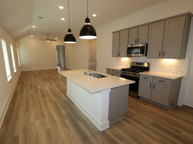 223 River Grove St, Willis, TX 77378 - kitchen with decorative backsplash, gray cabinets, wood finished floors, a sink, and stainless steel appliances