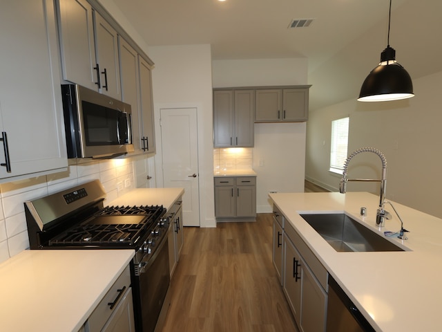 223 River Grove St, Willis, TX 77378 - kitchen with dark wood-style flooring, light countertops, gray cabinets, a sink, and stainless steel appliances