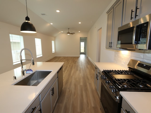 223 River Grove St, Willis, TX 77378 - kitchen featuring a sink, light wood-style floors, light countertops, stainless steel appliances, and tasteful backsplash