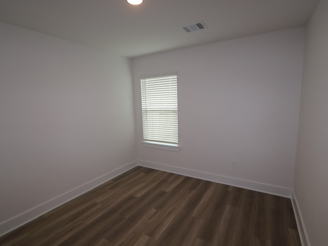 223 River Grove St, Willis, TX 77378 - spare room with visible vents, baseboards, and dark wood finished floors