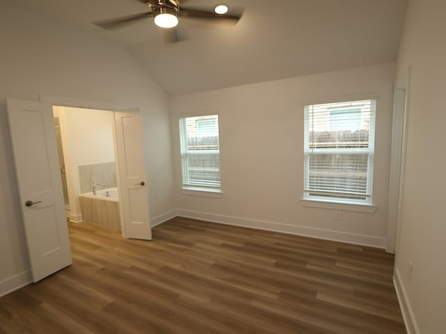 223 River Grove St, Willis, TX 77378 - unfurnished bedroom featuring ceiling fan, ensuite bath, baseboards, wood finished floors, and lofted ceiling