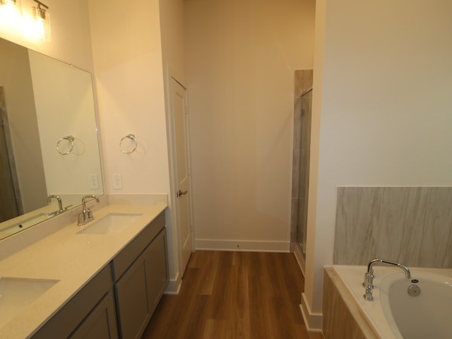 223 River Grove St, Willis, TX 77378 - bathroom featuring a sink, a garden tub, and wood finished floors