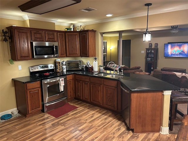 kitchen with sink, kitchen peninsula, stainless steel appliances, and light hardwood / wood-style flooring