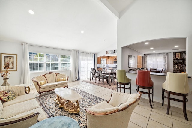 living room with light tile patterned floors and high vaulted ceiling