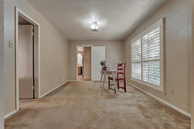 dining room with a textured ceiling and light carpet