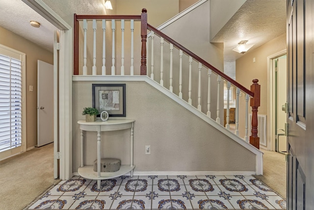 stairs with carpet flooring and a textured ceiling