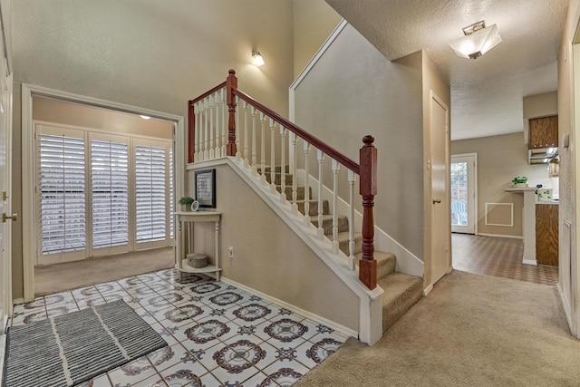 stairway with carpet and a textured ceiling