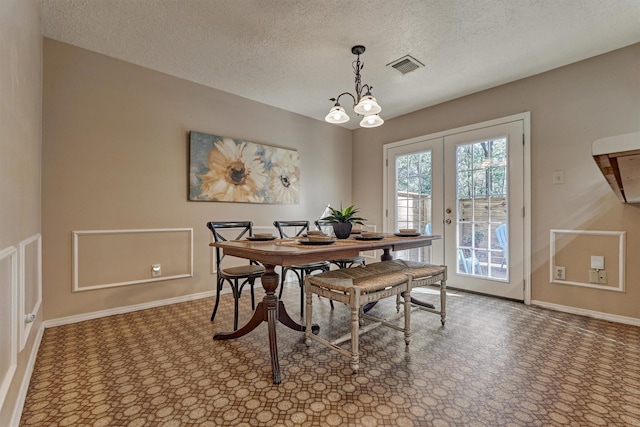 dining area with a textured ceiling and french doors