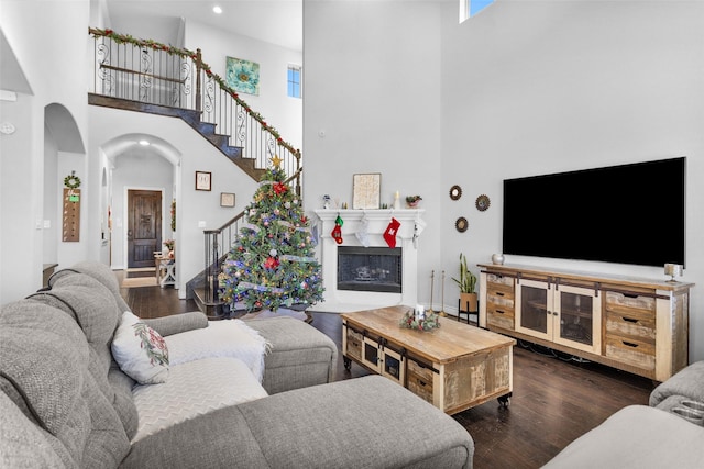 living room with dark hardwood / wood-style floors and a high ceiling