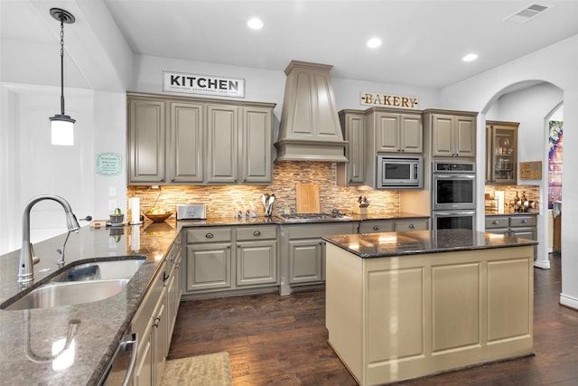 kitchen featuring dark stone countertops, dark wood-type flooring, sink, and stainless steel appliances