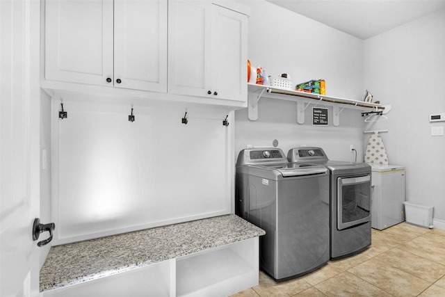 laundry room with cabinets, separate washer and dryer, and light tile patterned flooring