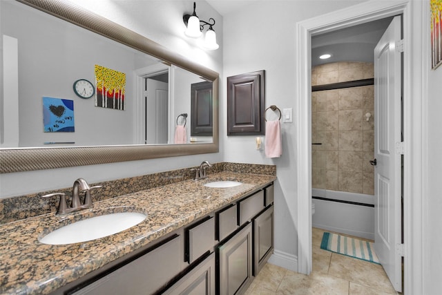 full bathroom with tile patterned floors, vanity, toilet, and bath / shower combo with glass door