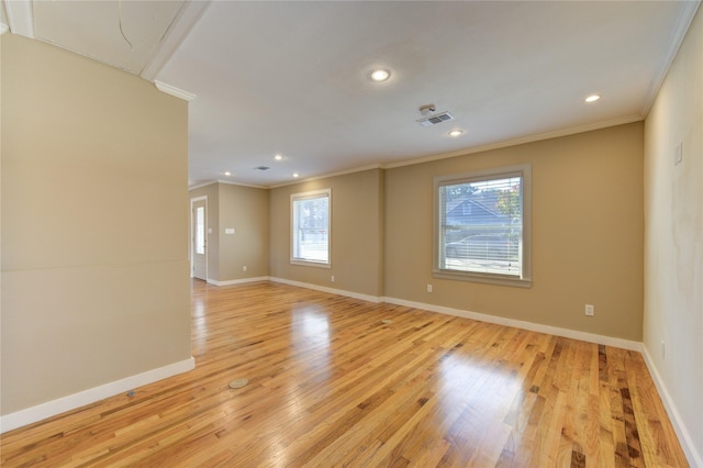 empty room featuring light hardwood / wood-style flooring, plenty of natural light, and ornamental molding