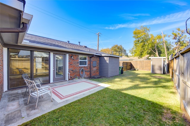 rear view of house with a lawn, a patio area, and a storage shed