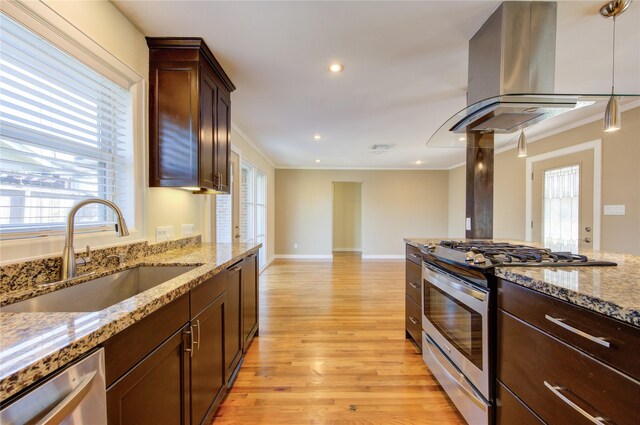 kitchen featuring sink, stainless steel appliances, light stone counters, island range hood, and ornamental molding